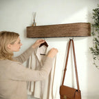 Walnut wood wall coat rack with flat shelf, woman hanging white shirt in bright Australian entryway