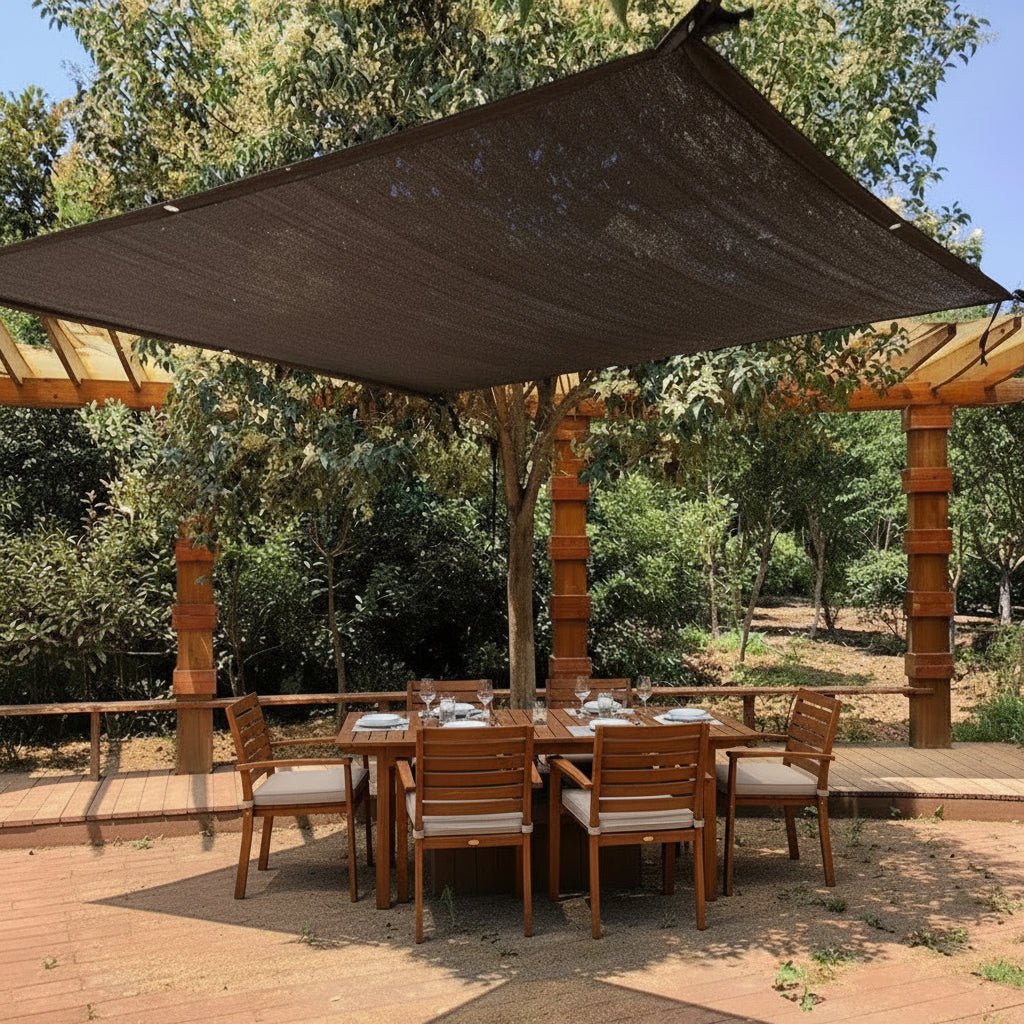 Dark brown rectangular shade sail installed over timber pergola and outdoor dining set in an Australian garden, afternoon light