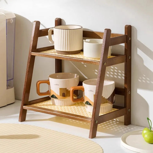 Two-tier bamboo kitchen shelf organiser holding mugs and accessories on white countertop