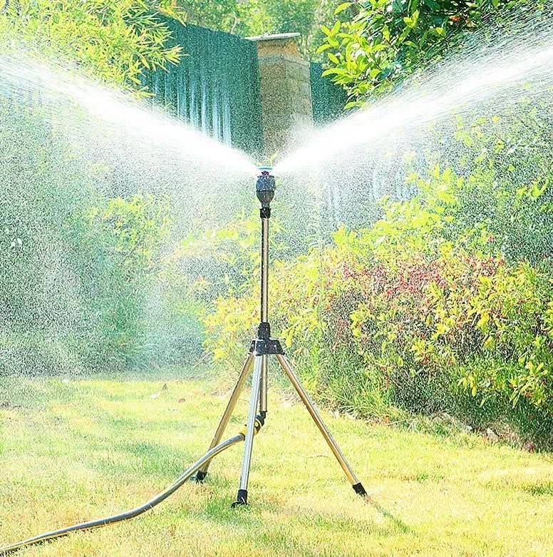 Garden sprinkler with stainless steel tripod spraying water in 360 degree pattern across lawn