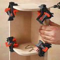 Orange black corner clamps securing wooden boards in perfect 90 degree angle woodworking assembly