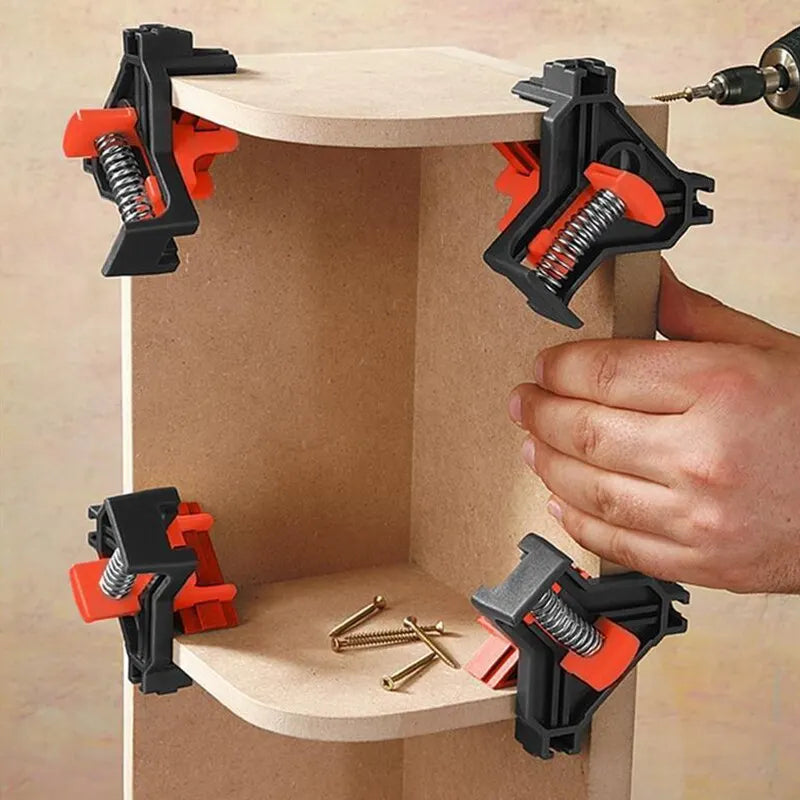 Orange black corner clamps securing wooden boards in perfect 90 degree angle woodworking assembly