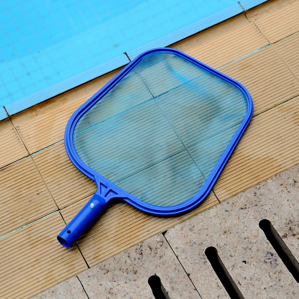 Blue pool leaf skimmer net with fine mesh frame resting on timber pool decking beside a clear outdoor swimming pool
