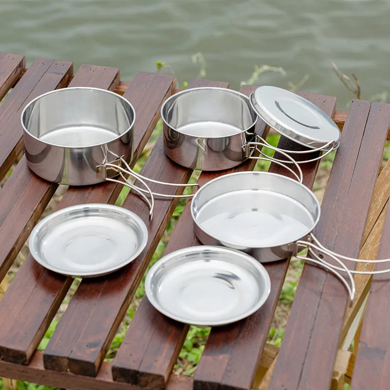 8-piece stainless steel camping cookware set with two pots, two pans and folding handles on white background