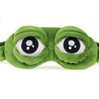 3D green plush frog eye sleep mask front view on white background showing embroidered eye detail and raised dome shape
