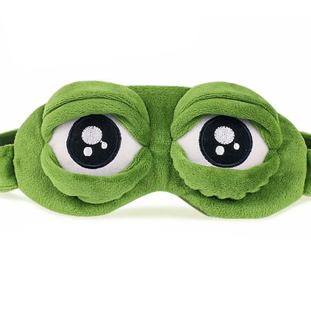 3D green plush frog eye sleep mask front view on white background showing embroidered eye detail and raised dome shape