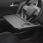 Car steering wheel table clipped to black steering wheel with laptop computer on surface