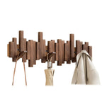 Walnut wood wall coat rack piano style design with staggered hooks mounted on white wall