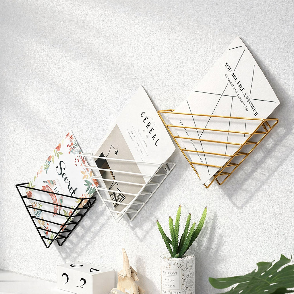 Metal wall-mounted shelf for books and magazines in white finish, front view in lounge room setting
