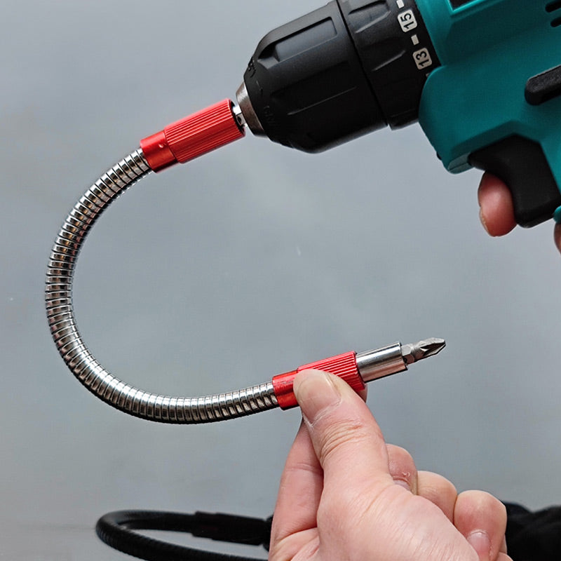 Flexible carbon steel drill bit extension bent in U-shape connected to cordless drill, red connector ends, grey background