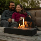 Tabletop bio-ethanol fire bowl with flames burning on wooden deck outdoor entertaining setting