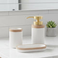 3-piece white ribbed bathroom set with wooden accent band and gold pump displayed on marble bench in modern bathroom