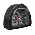Dark grey outdoor bike storage tent with arch frame and two bicycles stored inside on white background