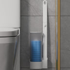 White wall-mounted disposable toilet brush with refill caddy on grey marble tile wall next to toilet