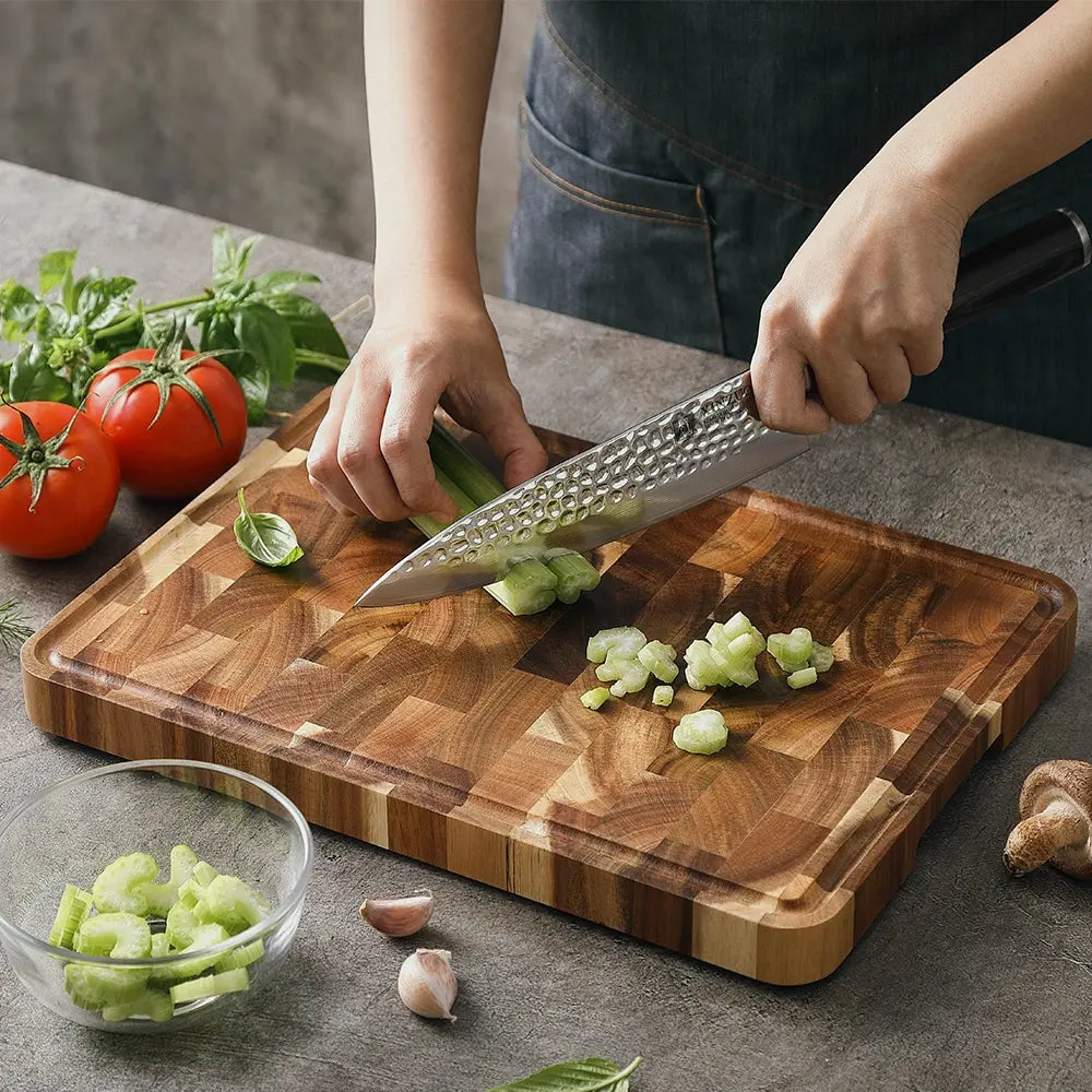 Acacia wood cutting board 35x25cm with vegetables being chopped showing end-grain construction