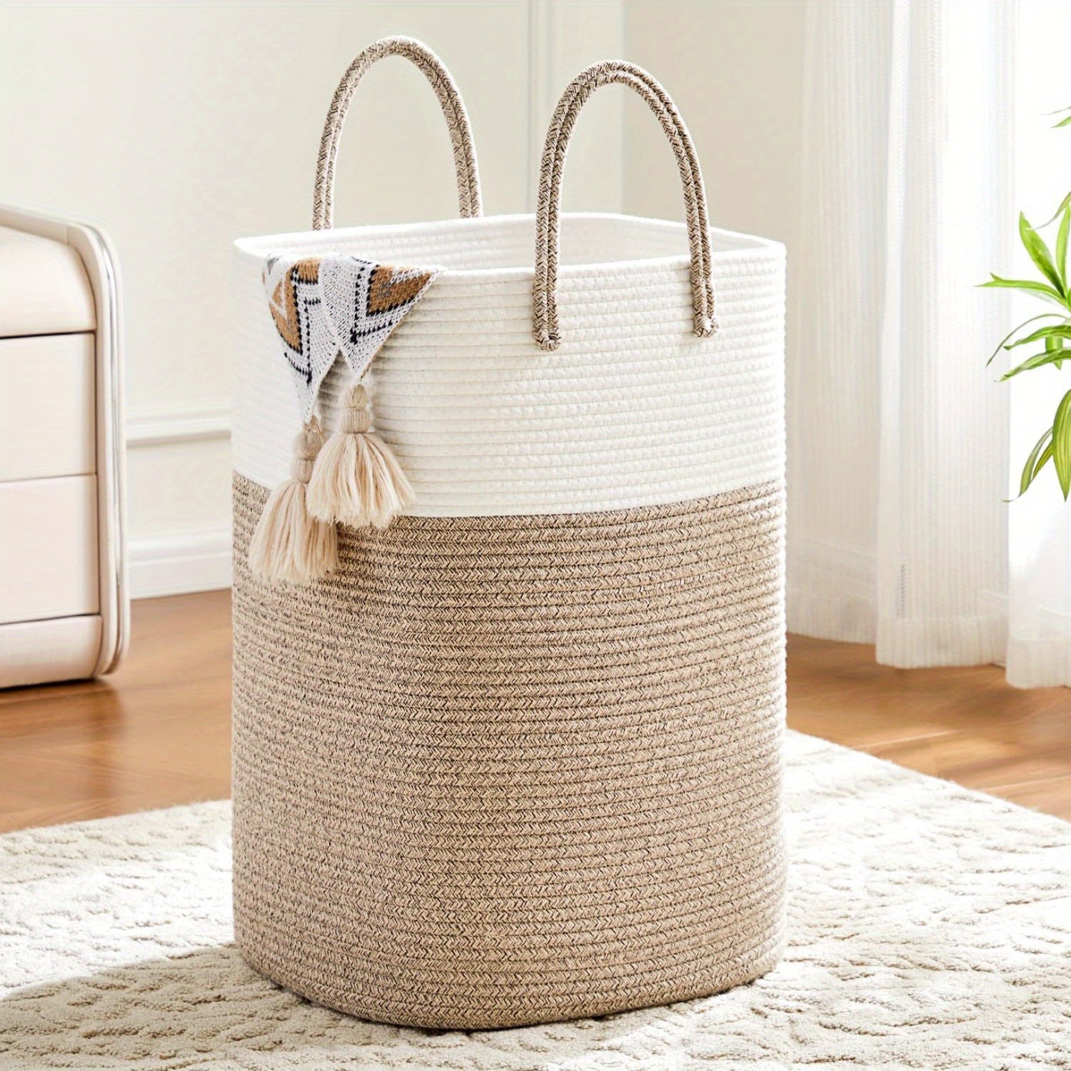 Large woven cotton laundry basket in brown and white two-tone rope design with braided handles, styled in a lounge room on timber floor