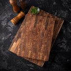 Teak wood cutting board with distinctive end-grain pattern on white background showing natural brown tones