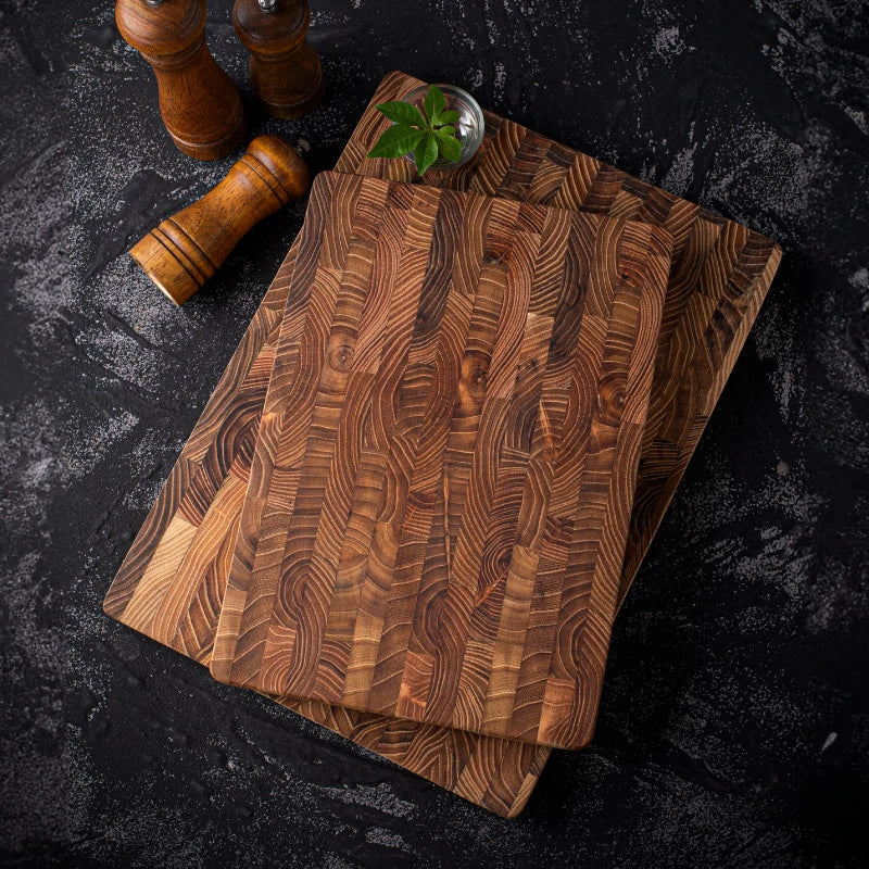 Teak wood cutting board with distinctive end-grain pattern on white background showing natural brown tones