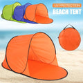 Orange and green and blue pop-up beach tents arranged together on sandy beach with blue sky background