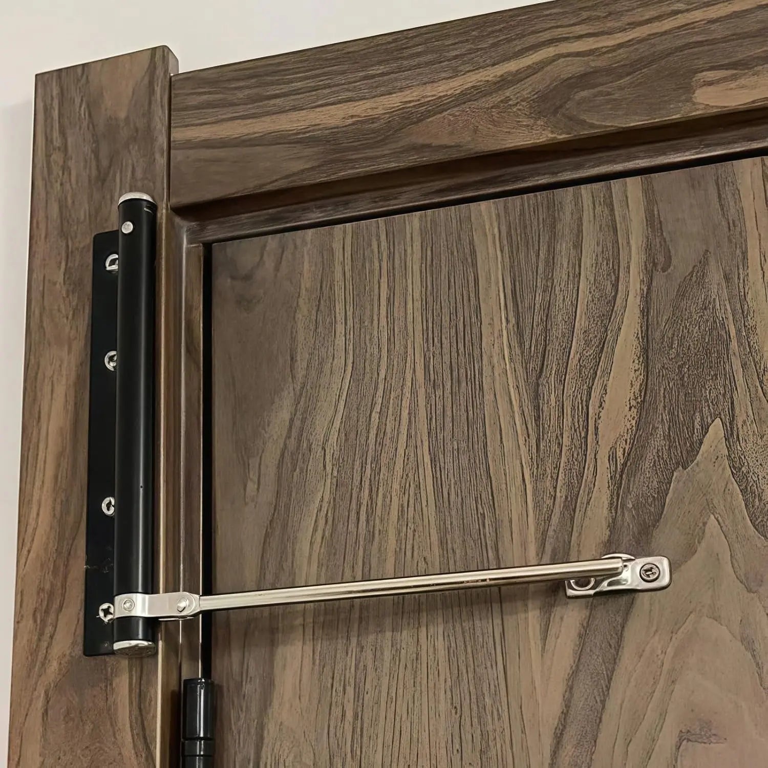 Hand adjusting speed setting dial on door closer mechanism close-up detail showing adjustment options