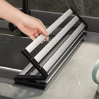 Adjustable drain rack with slatted stainless steel base and rubber corner holders white background