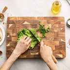 Professional cutting board solid acacia wood 34x24cm angled view showing grip detail white studio