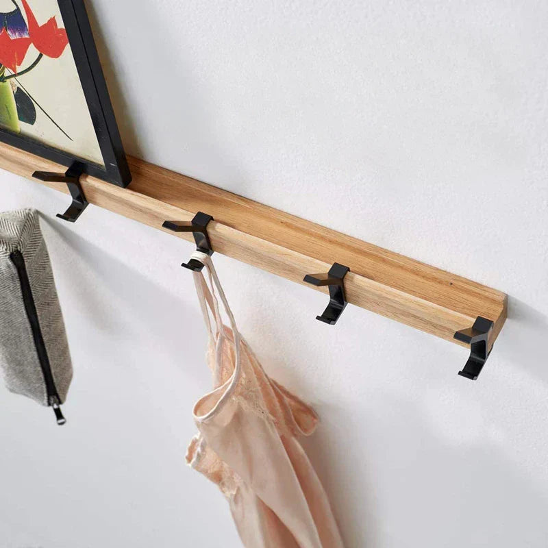 Close-up of rubberwood rail and black aluminium double hooks on wall coat rack angled view