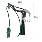 Black rope branch pruner held upward toward leafy tree branches in an Australian backyard garden setting