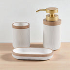 Soap dispenser, toothbrush cup and soap dish in white polyresin with wooden trim on white studio background