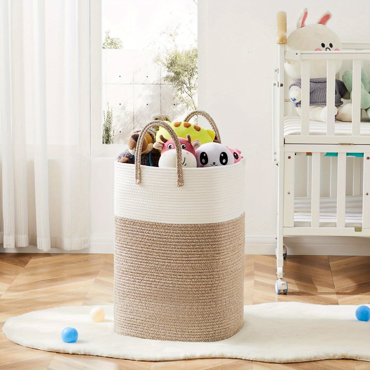 Woven cotton basket with foldable design and carry handles, full of colourful soft toys in a bright children's nursery room