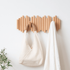 Wooden wall coat rack with folding wooden hooks shown flat on pure white background, natural light wood grain finish clearly visible
