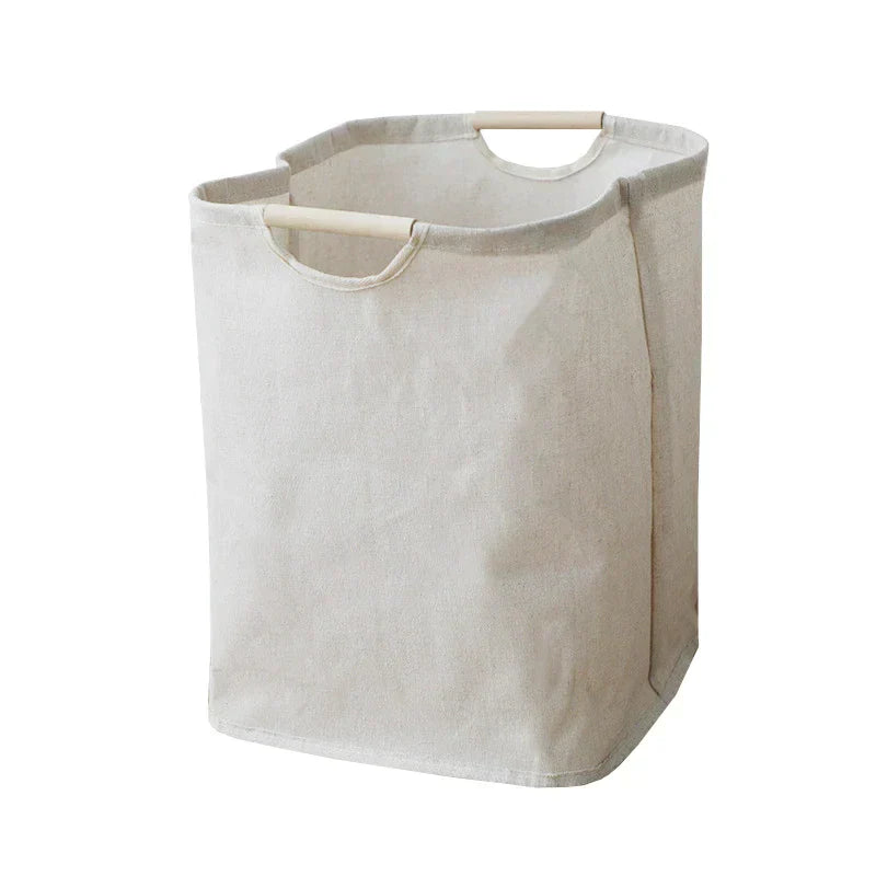 Foldable cotton-linen laundry basket natural beige with wooden handles on white studio background angled view