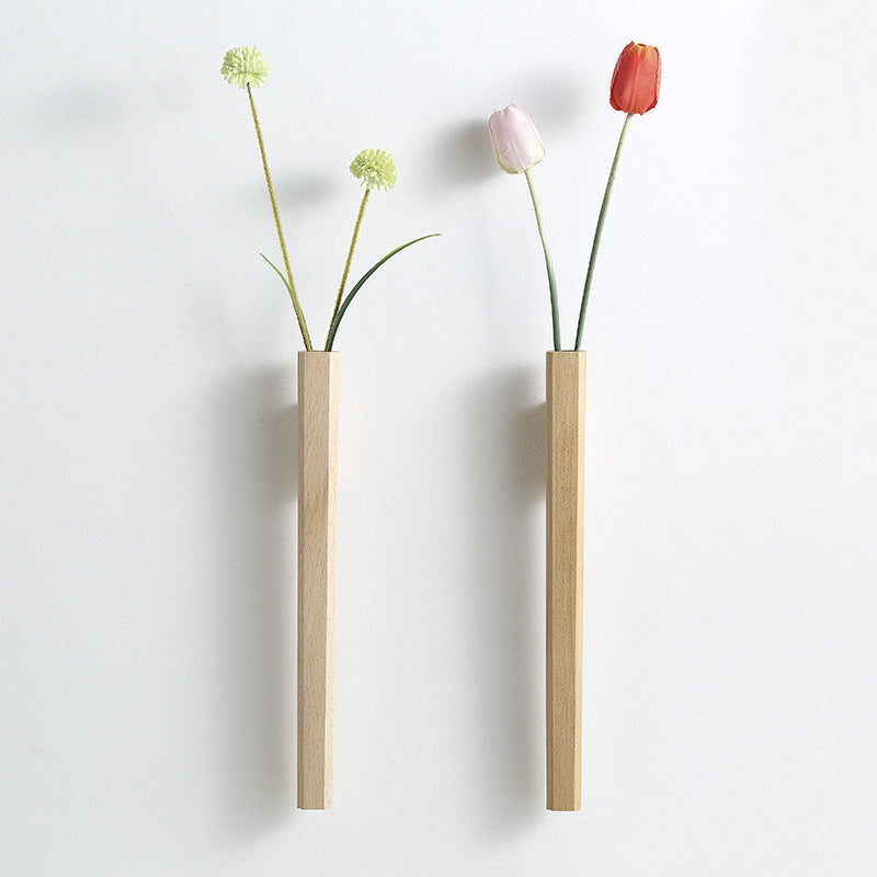 Two slim wooden hanging wall vases one dark walnut one light beech on pure white studio background