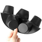 Black silicone air fryer muffin mould held in hand showing flexible material and matte finish close-up