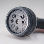 Garden spray gun nozzle head close up detail showing multiple spray pattern selection rings