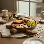 Wooden turtle serving board styled on dining table with white plates and floral arrangements for casual entertaining