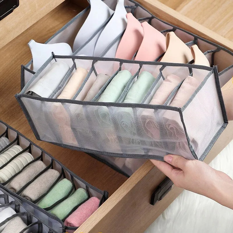 Grey nylon mesh 7-grid sock organiser on white background showing all compartments filled with rolled socks from above