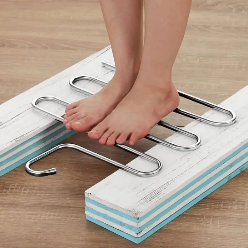 Set of three 5-layer stainless steel pants hangers on a rail, each loaded with folded trousers in a wardrobe