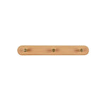 Walnut wood 3-hook coat rack on a light wall in a tidy bedroom, linen bag and scarf on hooks
