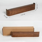 Wall coat rack walnut finish with hooks, woman in knitwear hanging garment on hanger, reed diffuser on shelf