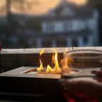 Bio-ethanol fire bowl on outdoor table patio setting evening ambience flames visible