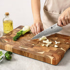 Acacia wood cutting board on modern kitchen marble bench with fresh vegetables prep workspace