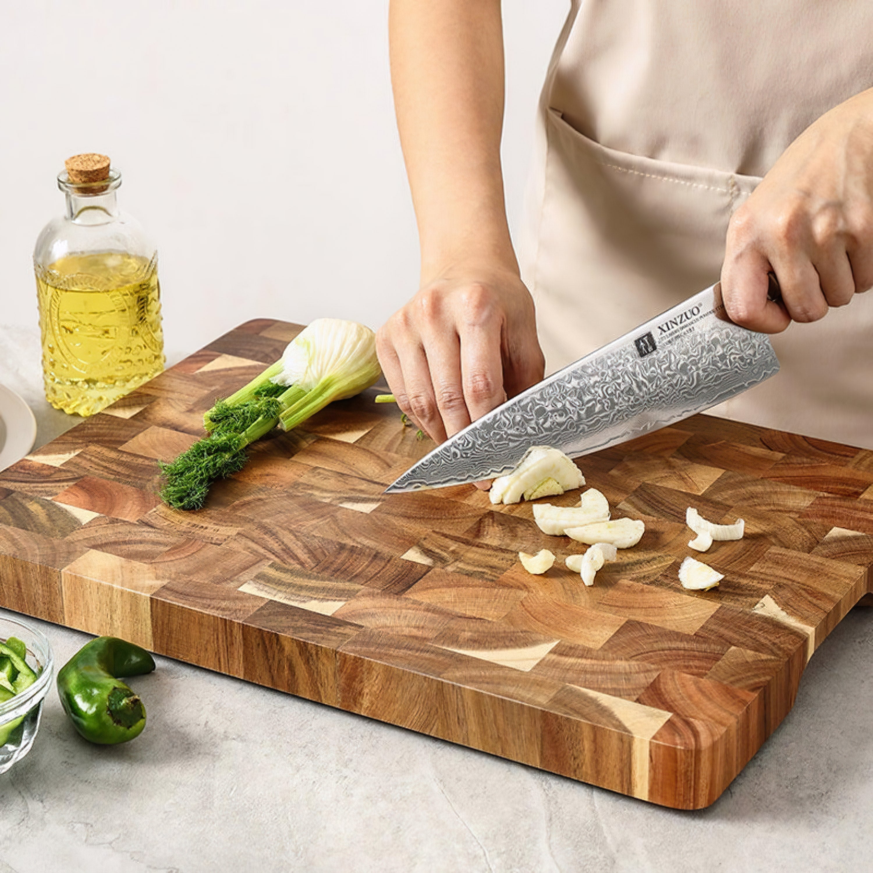 Acacia wood cutting board on modern kitchen marble bench with fresh vegetables prep workspace