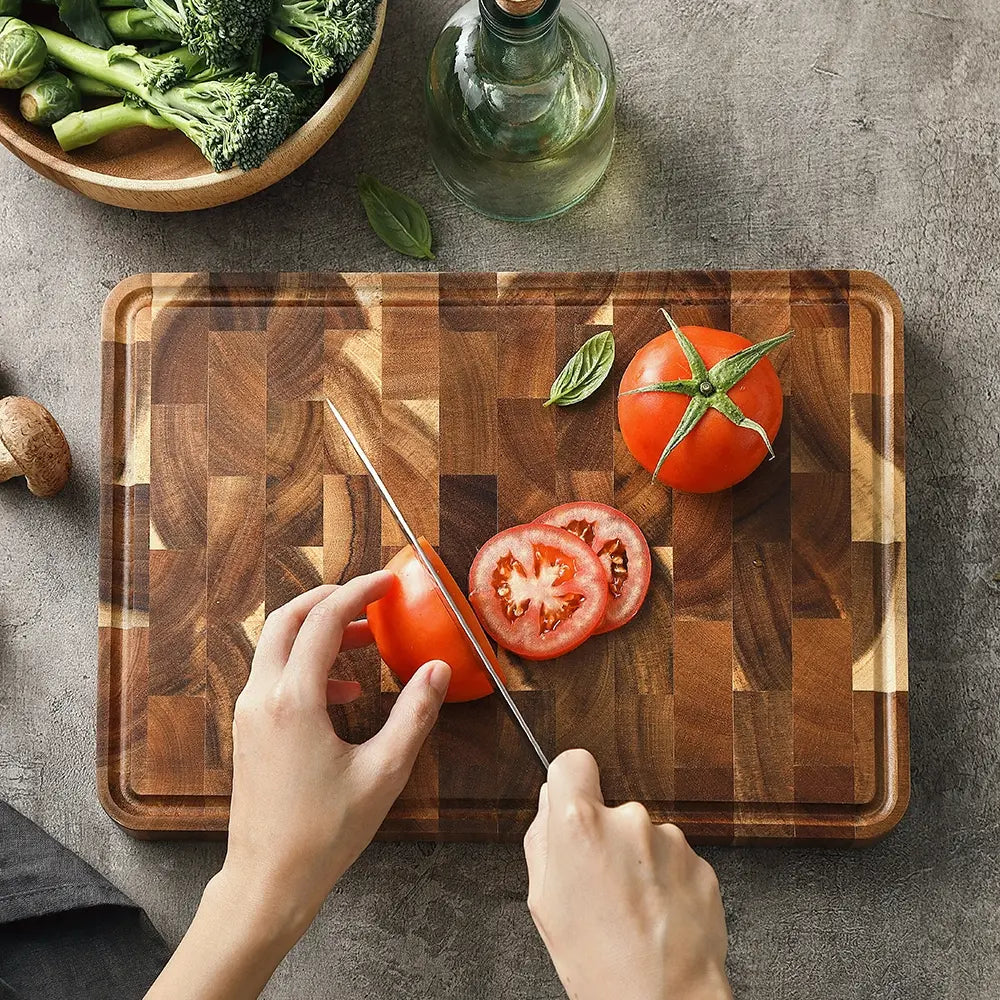Acacia cutting board styled with sliced steak herbs and seasonings for serving presentation