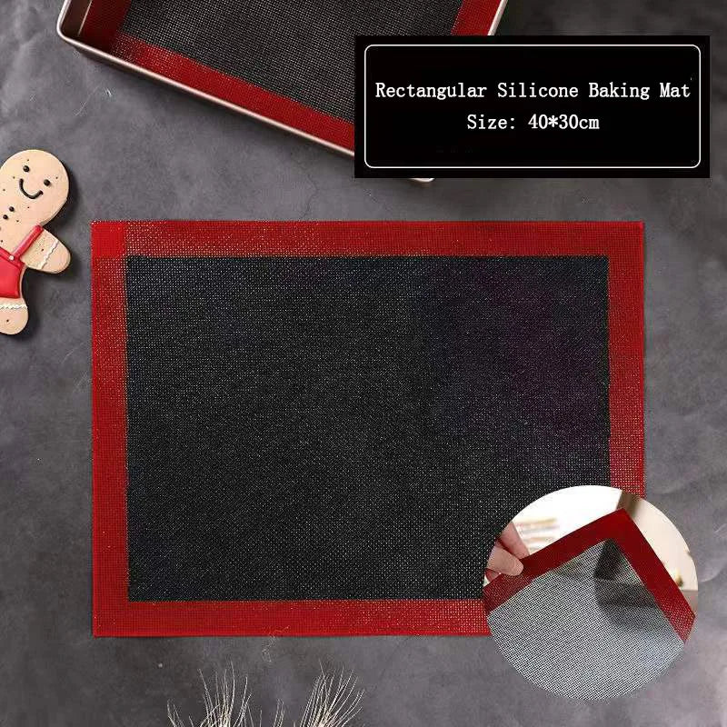 Black silicone baking mat on oven tray with unbaked cookie shapes, kitchen oven open in background