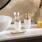 White ridged soap dispenser with brushed gold pump and warm wooden band styled on bathroom bench with succulent and linen towel