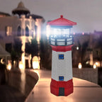 Maritime lighthouse garden decoration positioned on stone garden border with green plants