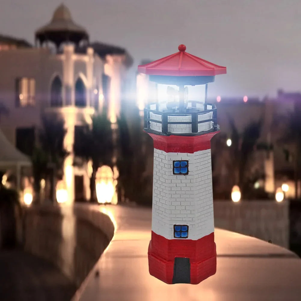 Maritime lighthouse garden decoration positioned on stone garden border with green plants