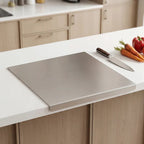 Steel cutting board positioned on marble kitchen benchtop in modern home setting