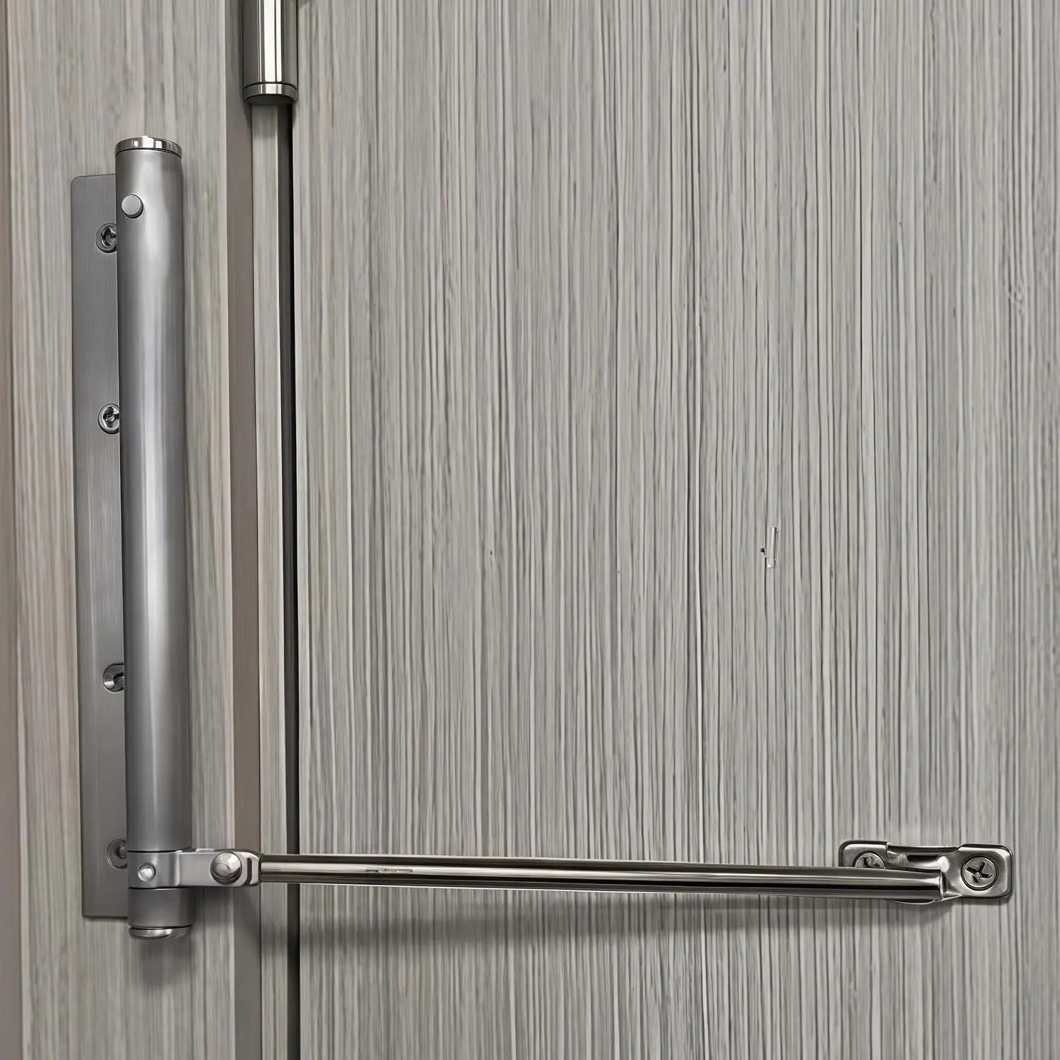 Silver finish automatic door closer mounted on light wood door in modern home interior setting